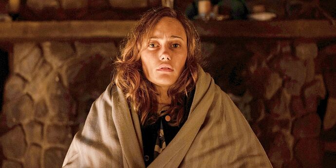 Jackie looking shocked while covering herself with a comforter in Yellowjackets.