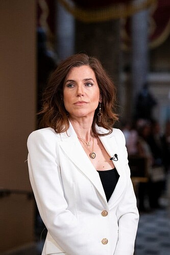 Representative Nancy Mace stands in the halls of Congress. She’s wearing a white blazer with a black top.