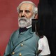 A man rolling black paint over a mural of Robert E. Lee